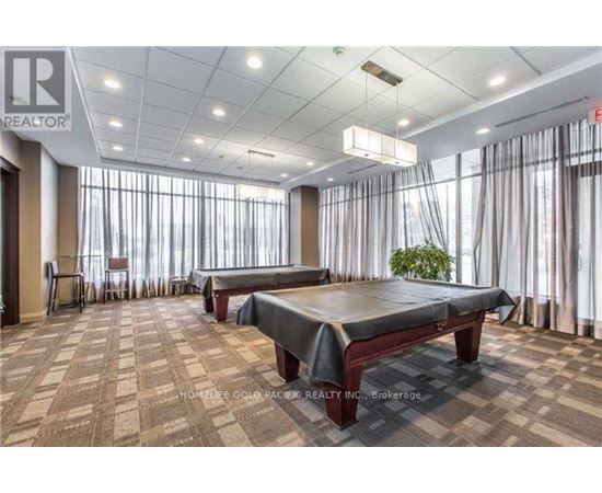 A spacious room with a massage table and a plant in the corner.