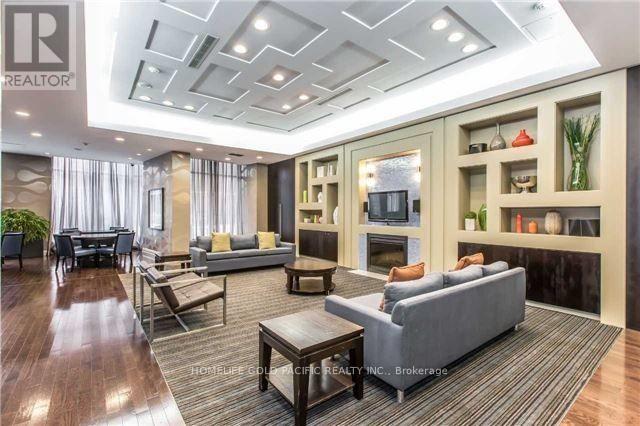 A well-lit, spacious living room with a grey sofa and wooden coffee table.