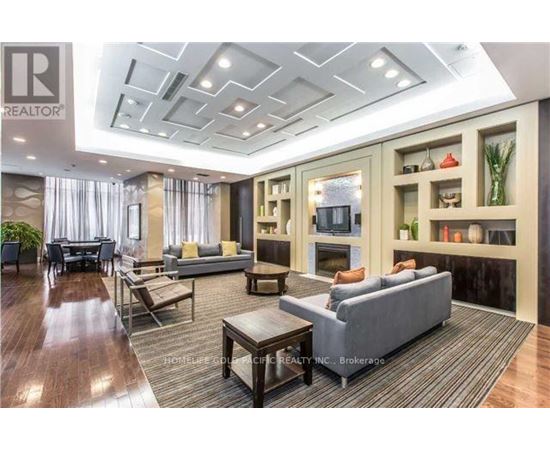 A well-lit, spacious living room with a grey sofa and wooden coffee table.
