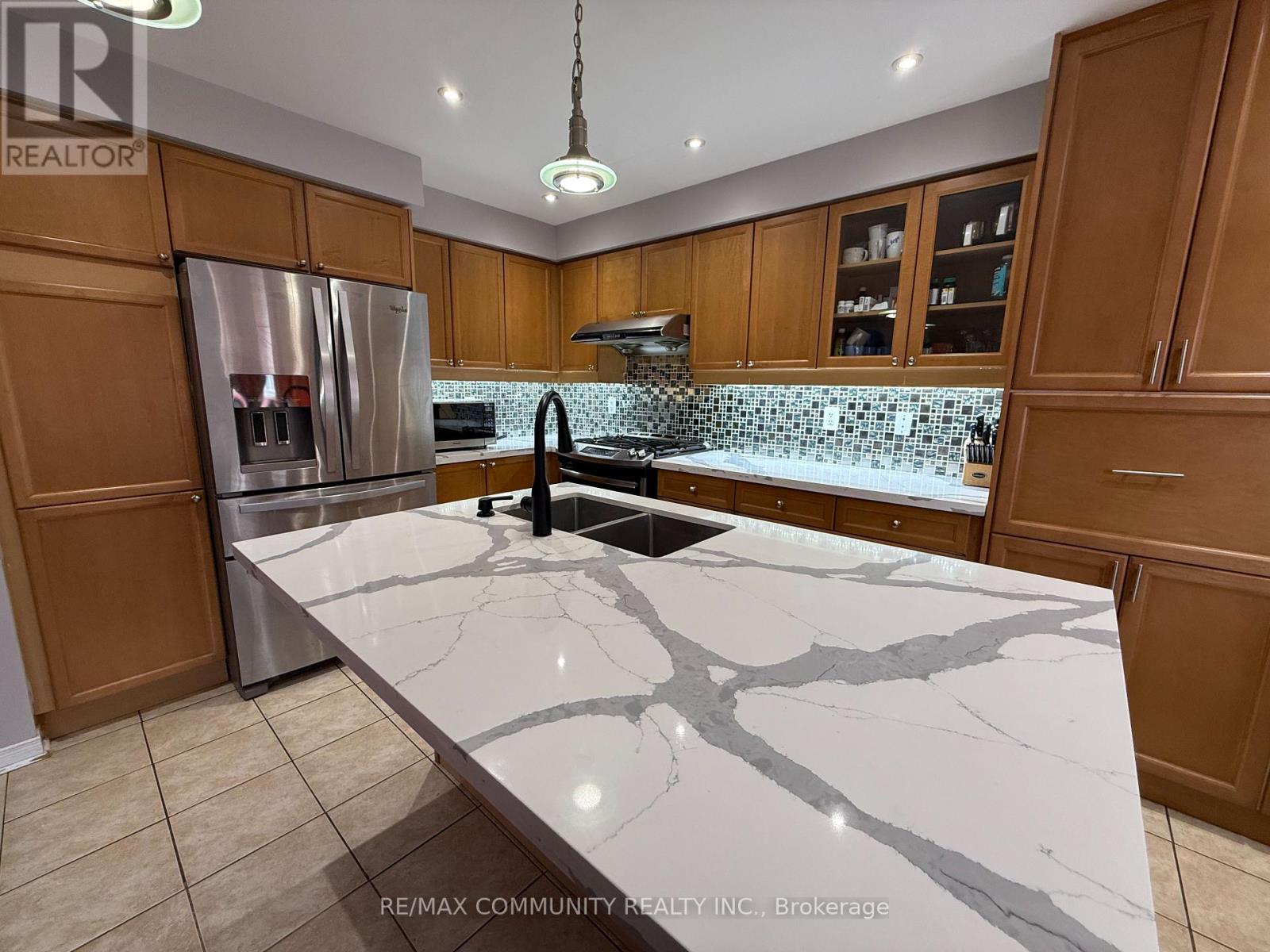 A kitchen with a marble countertop and wooden cabinets.