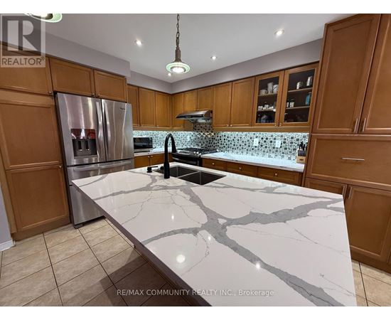 A kitchen with a marble countertop and wooden cabinets.