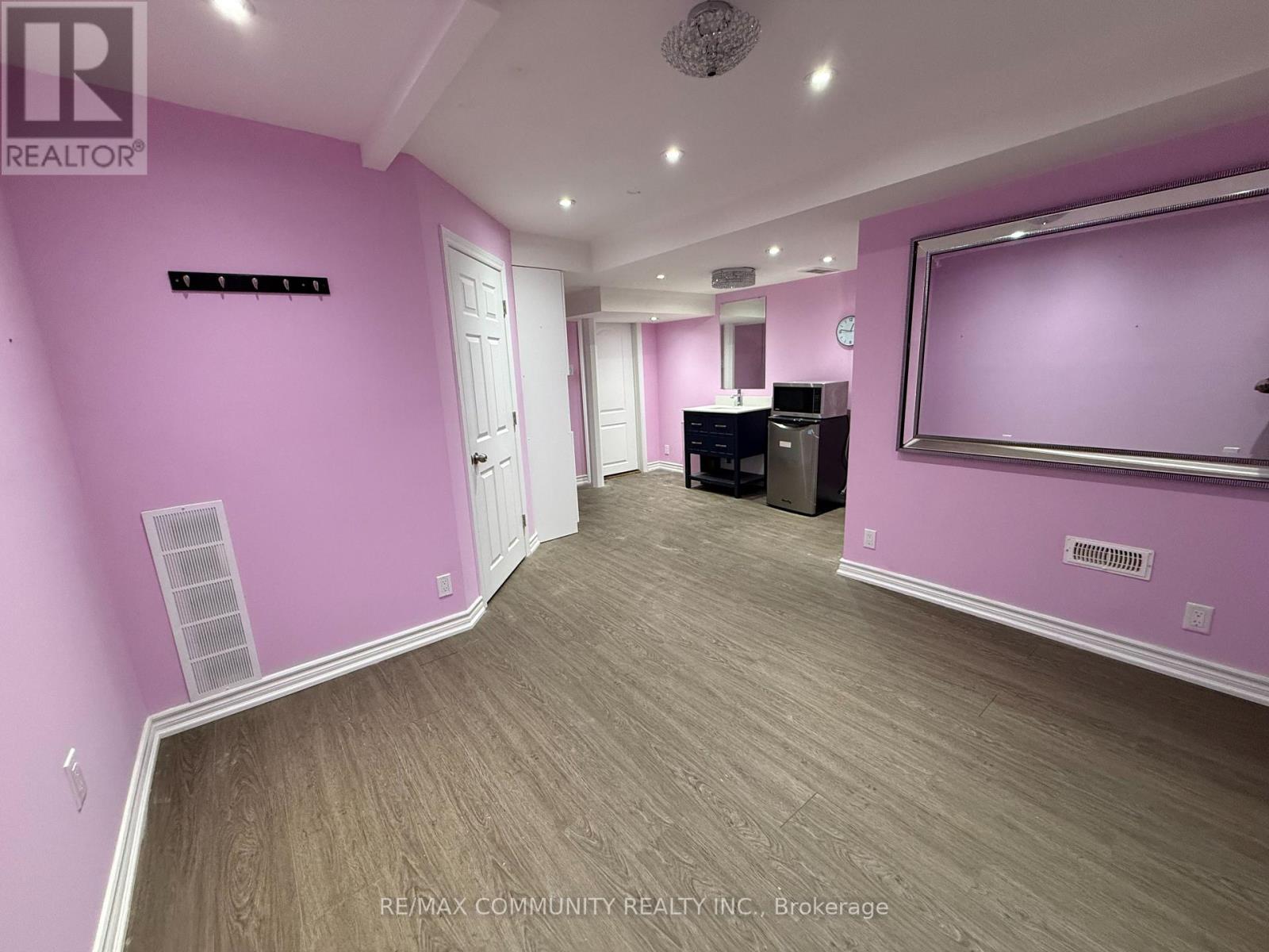 A room with pink walls and a wooden floor.