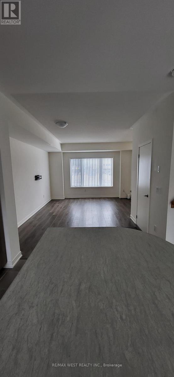 A spacious room with a grey carpet and white walls.