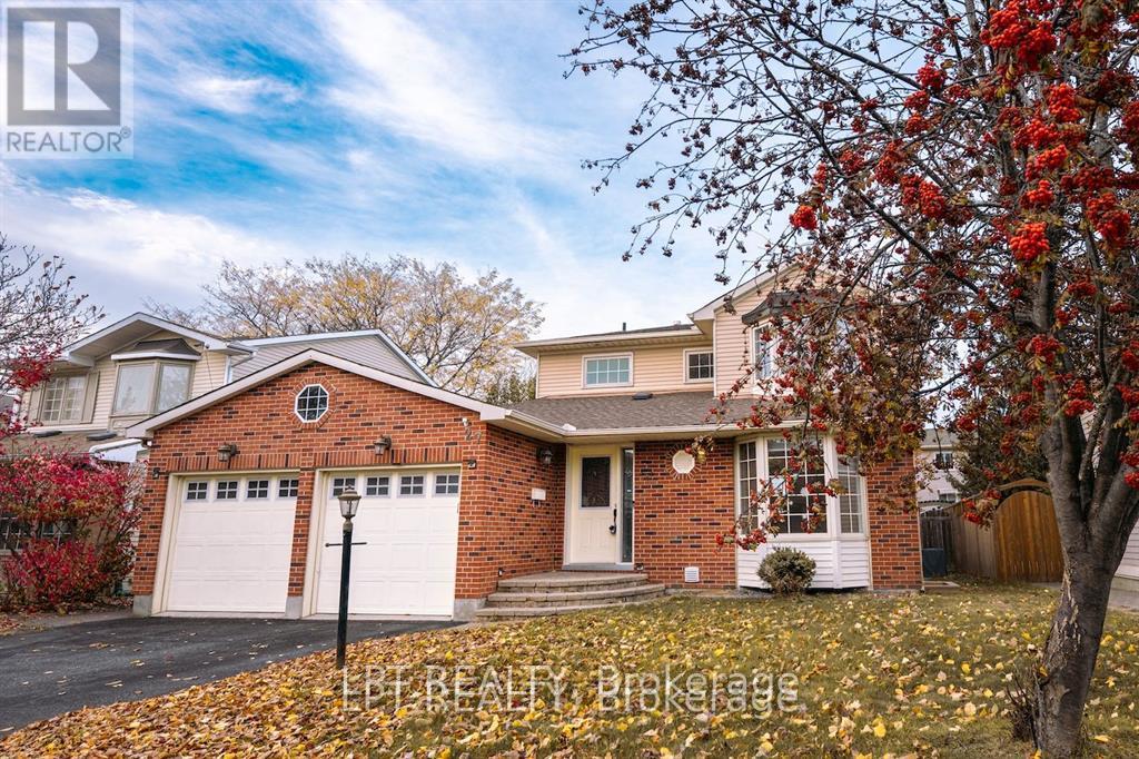 A house with a red brick exterior and a white garage door is surrounded by fallen leaves.