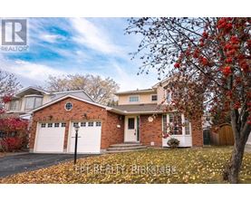A house with a red brick exterior and a white garage door is surrounded by fallen leaves.