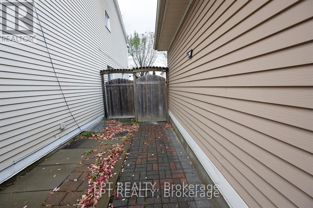 A narrow alley with a wooden fence and a brick path.