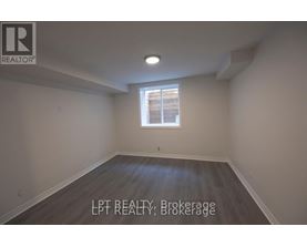 A room with a window and wooden flooring.