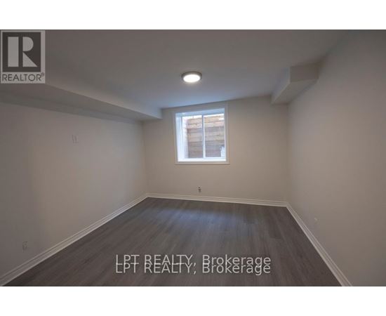 A room with a window and wooden flooring.