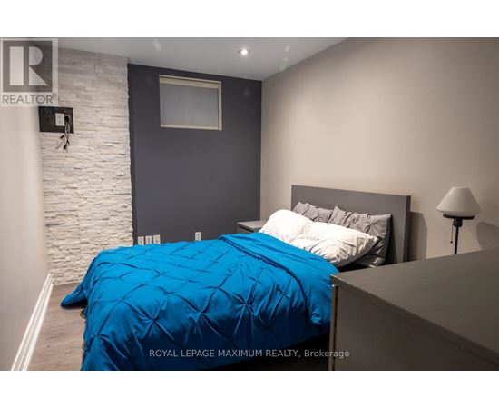 A bedroom with a blue bedspread and a white bed.