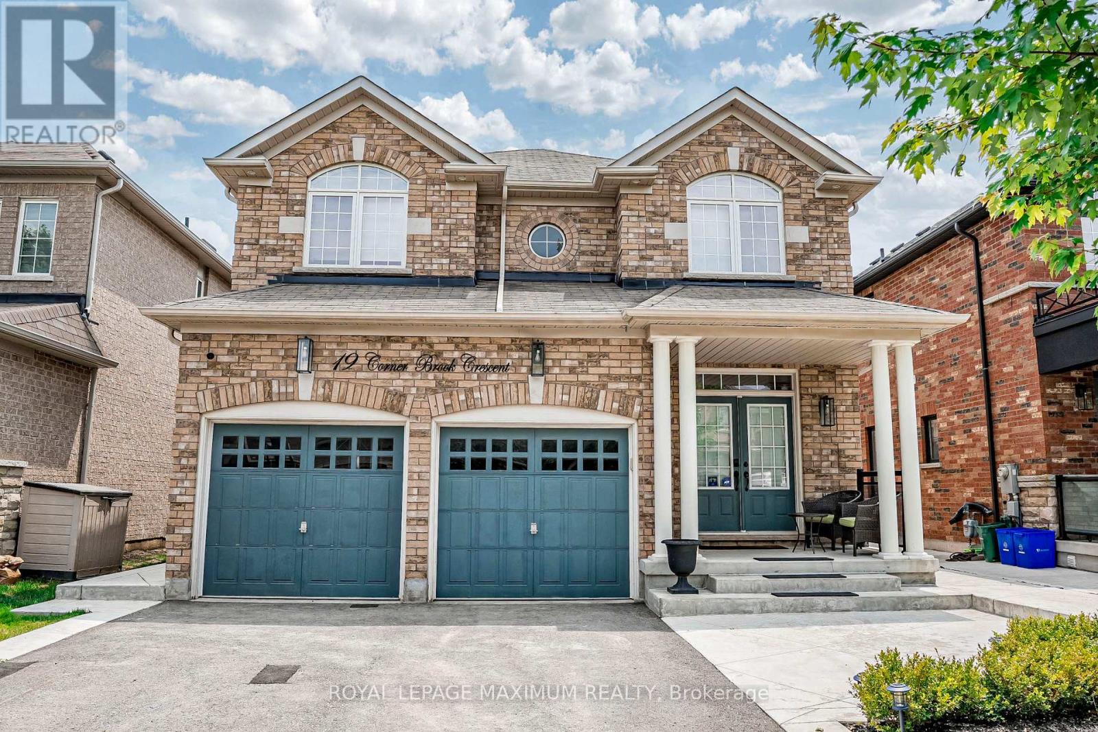 A two-story house with a brick facade and two garage doors.