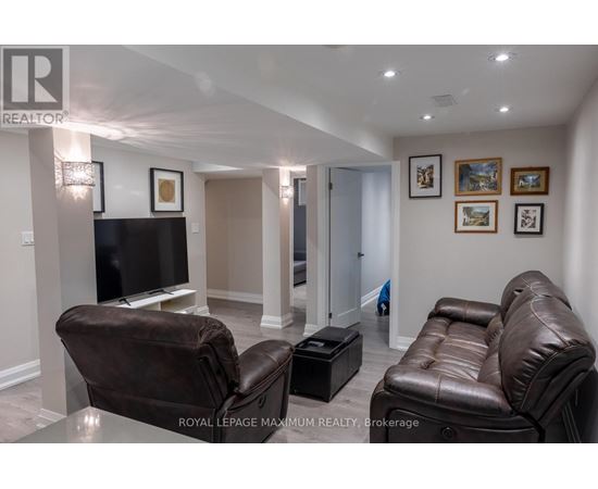 A living room with a brown leather couch and a black television.