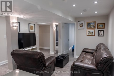 A living room with a brown leather couch and a black television.