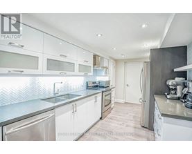A modern kitchen with white cabinets and stainless steel appliances.
