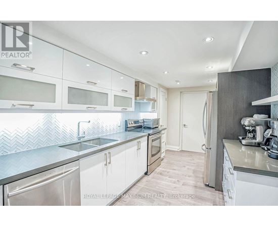 A modern kitchen with white cabinets and stainless steel appliances.