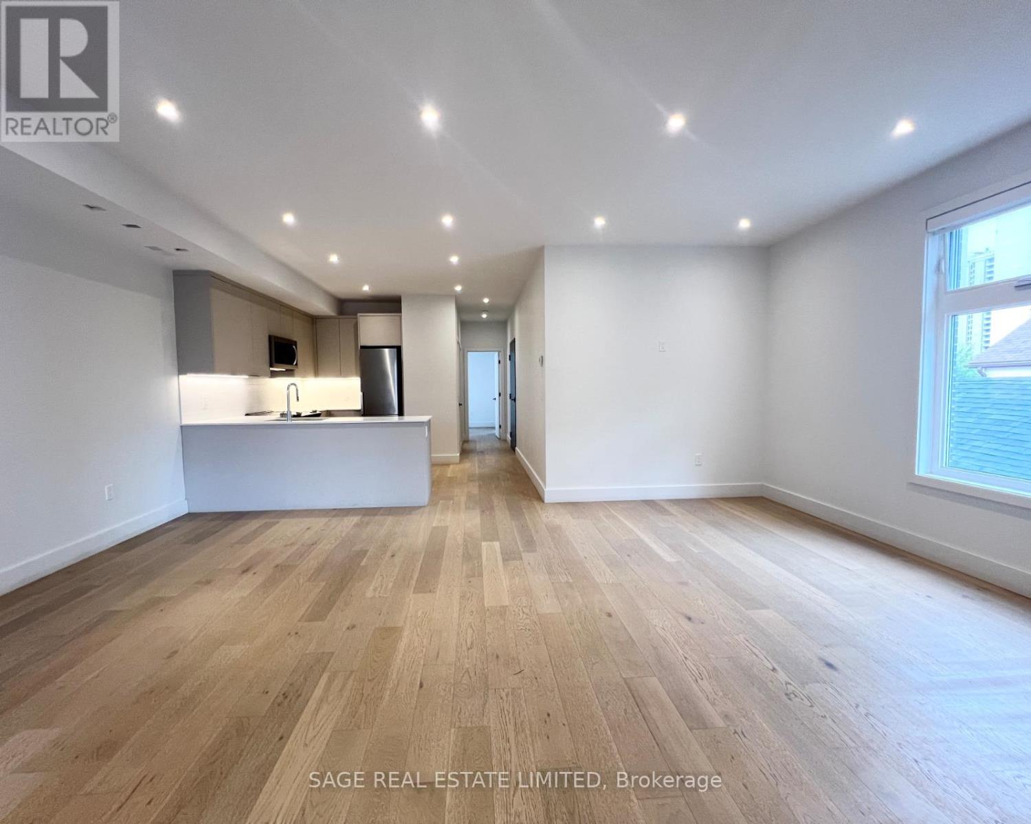 A spacious room with wooden flooring and a reception desk.