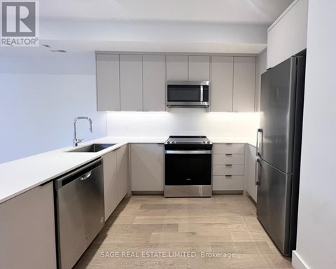 A modern kitchen with stainless steel appliances and a microwave above the stove.