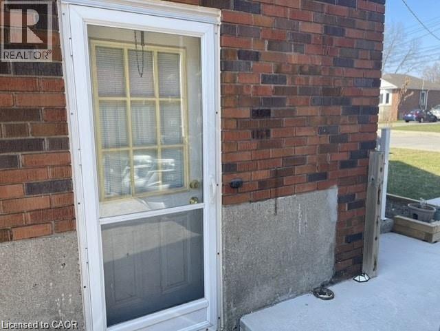 A window on a brick wall with a sign that says REALTOR above it.