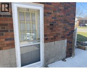 A window on a brick wall with a sign that says REALTOR above it.
