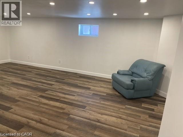 A room with a blue chair and wooden flooring.