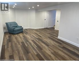 A room with wooden flooring and a blue chair.