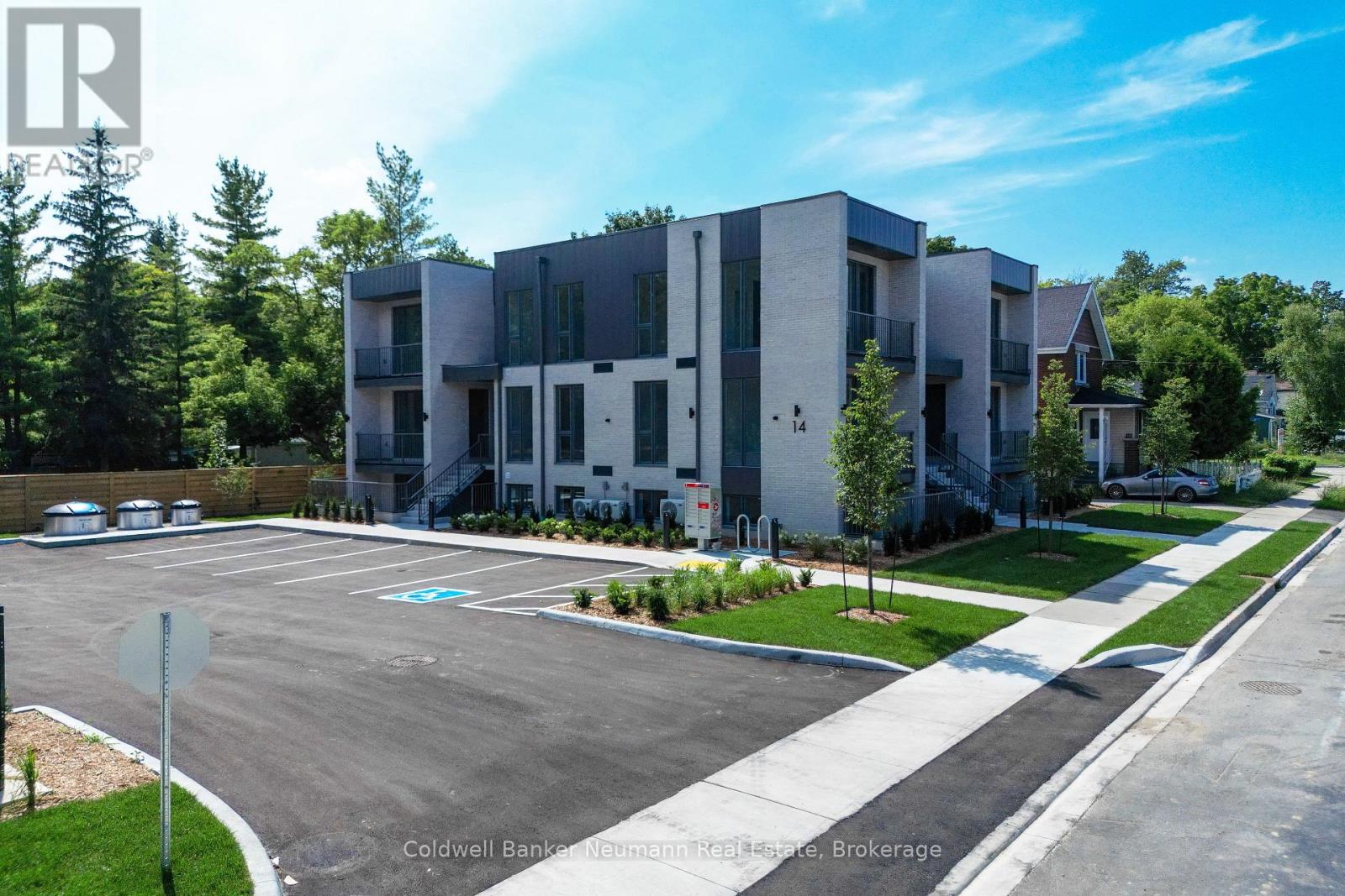 A modern apartment complex with a parking lot in front.