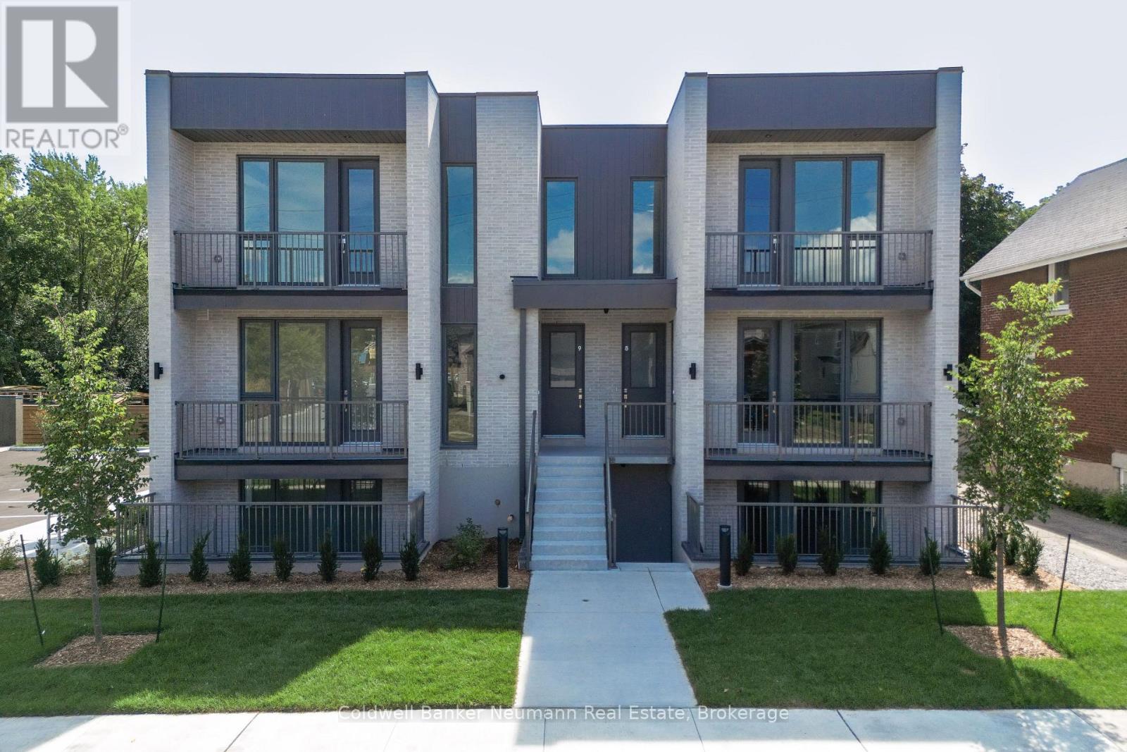 A modern two story townhouse with a balcony on each floor.