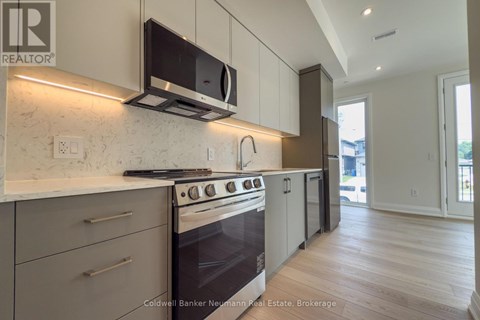 A modern kitchen with a stove top oven and microwave.