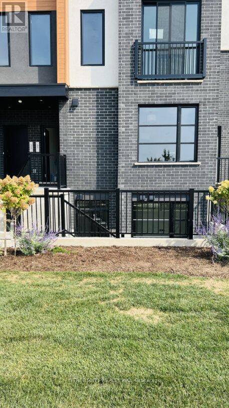 A modern house with a black front door and a small garden.