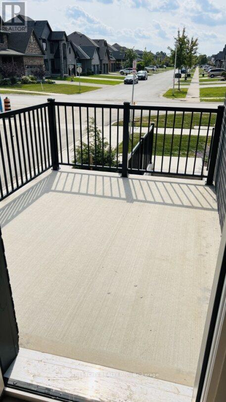 A balcony with a black railing and a concrete floor.