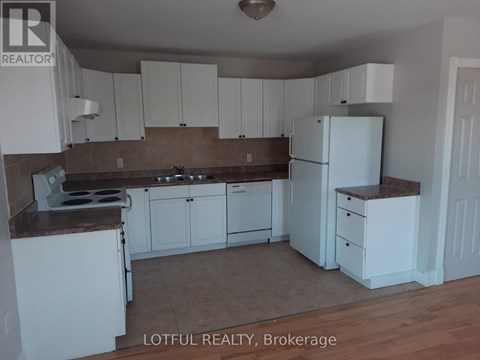 A kitchen with white cabinets and a white refrigerator.