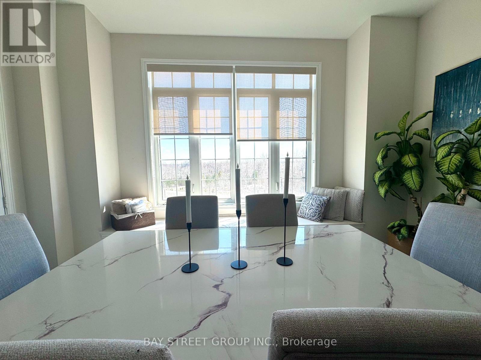 A dining room with a marble table and chairs.