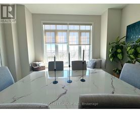 A dining room with a marble table and chairs.