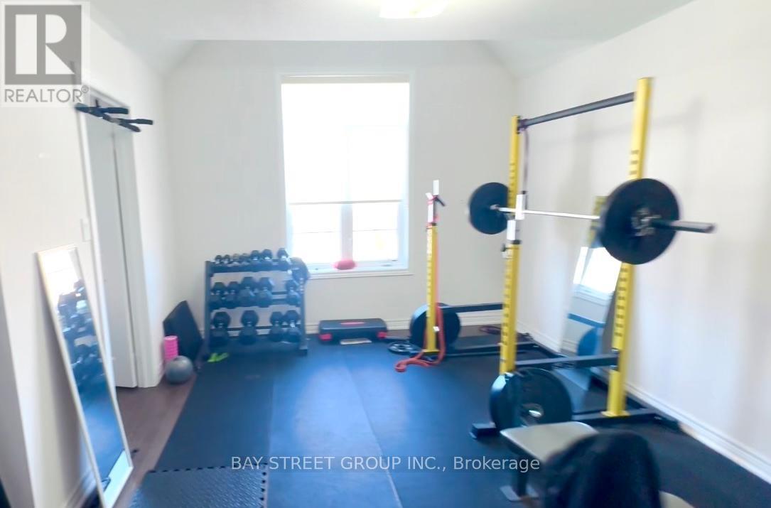 A gym room with a squat rack, weights and a bench.