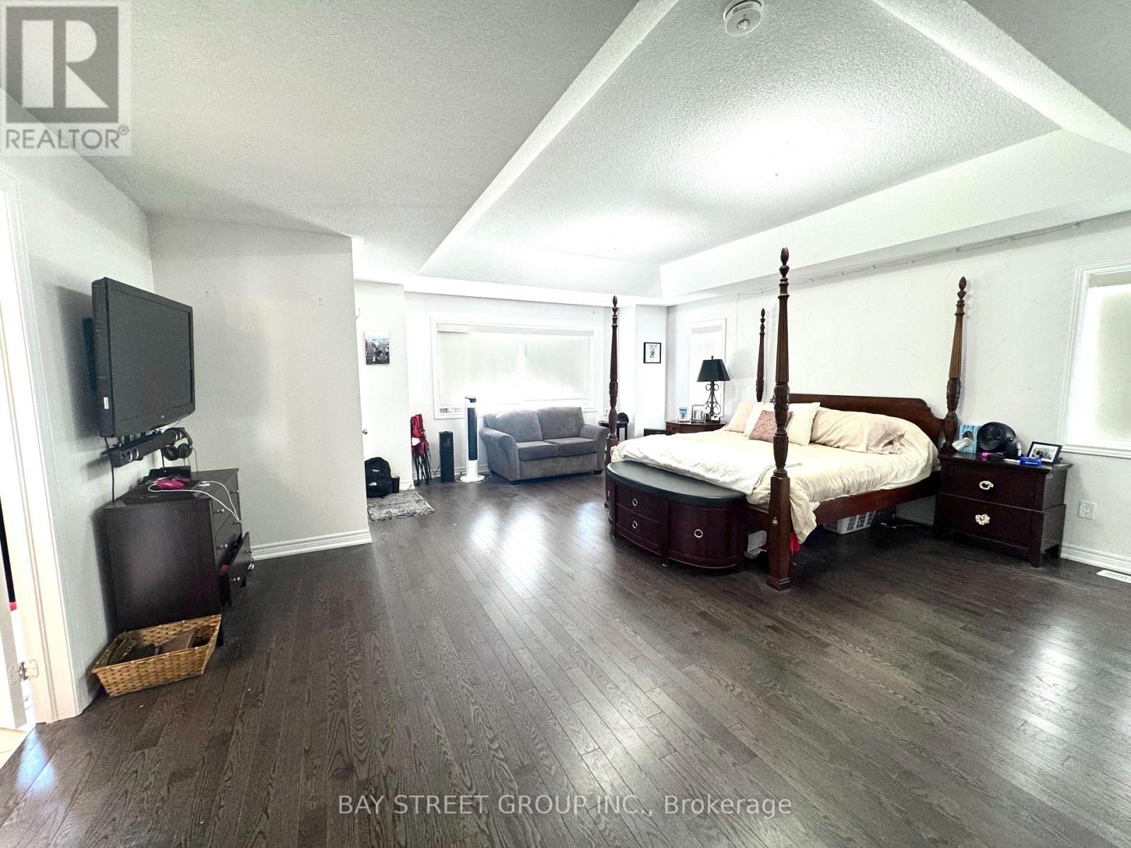 A bedroom with a four poster bed and a television.