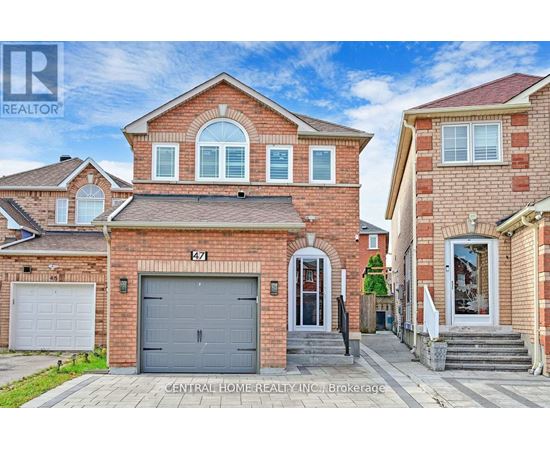 A red brick house with a grey garage door is for sale.