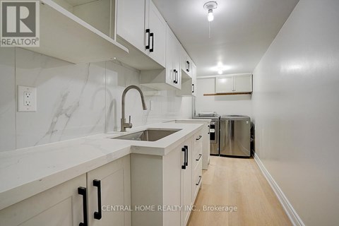 A kitchen with white cabinets and a marble counter top.