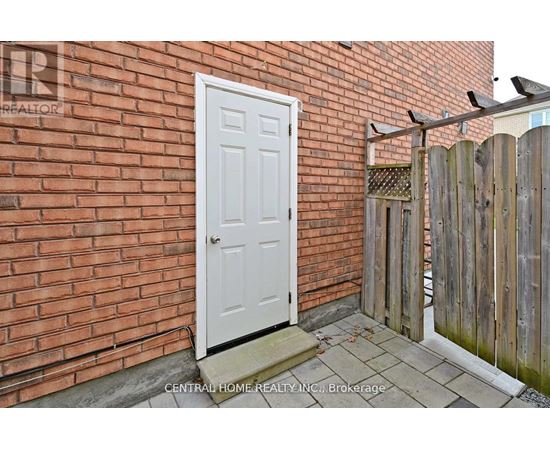 A white door is on the left side of a brick wall.