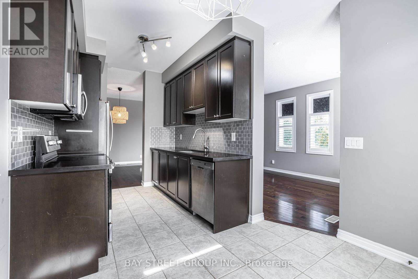 A modern kitchen with dark wood cabinets and a tiled backsplash.