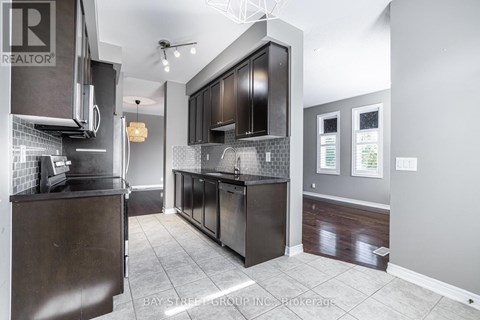 A modern kitchen with dark wood cabinets and a tiled backsplash.