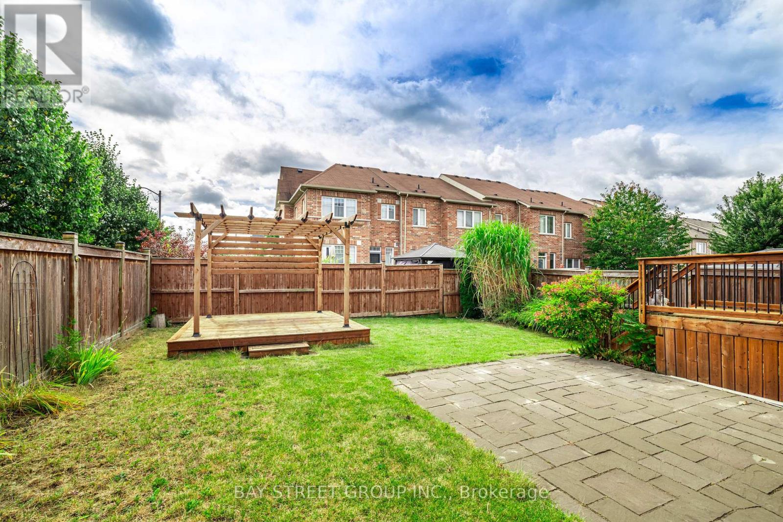 A backyard with a wooden deck and a grassy area.