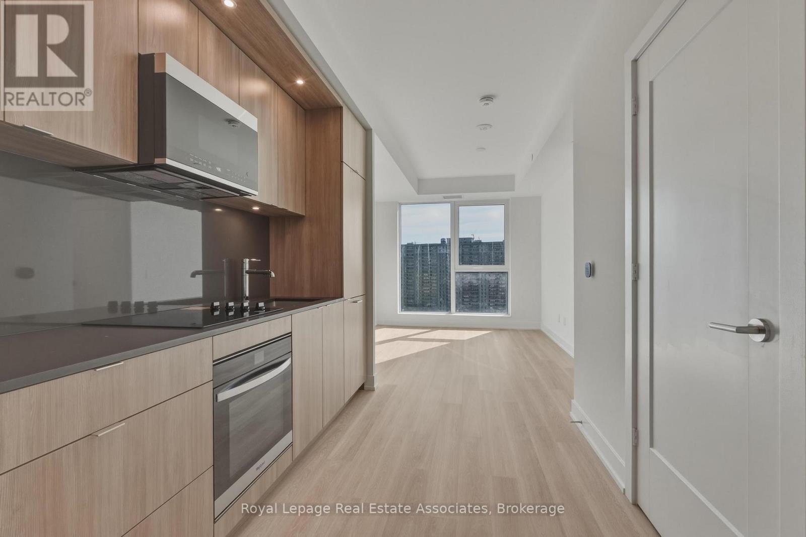 A modern kitchen with wooden cabinets and stainless steel appliances.