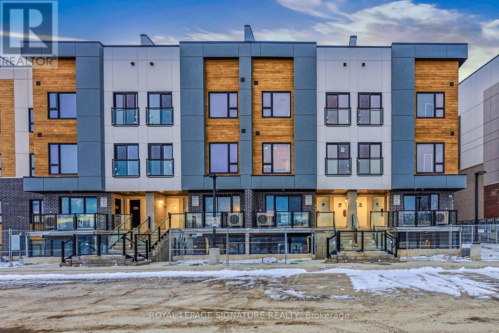 A modern multi-story building with a mix of wood and grey exterior walls.