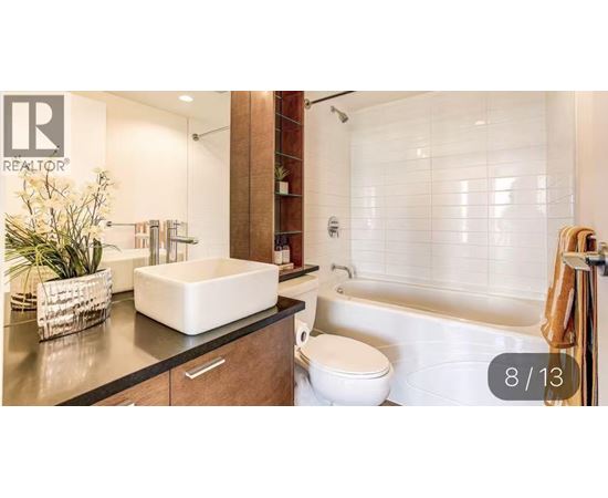 A modern bathroom with a white toilet and a bathtub.