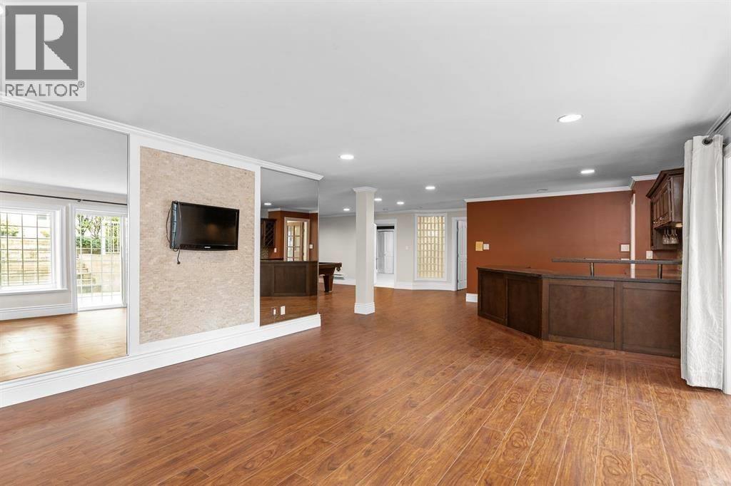 A spacious living room with wooden floors and a large television.