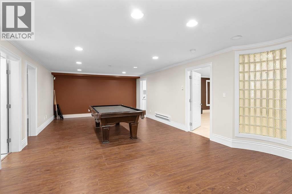 A room with a brown wall and a pool table.