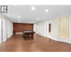 A room with a brown wall and a pool table.