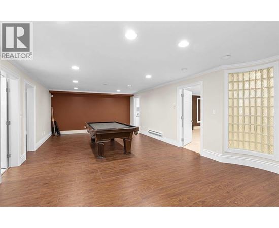 A room with a brown wall and a pool table.