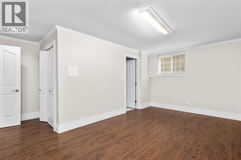 A room with wood flooring and white walls.