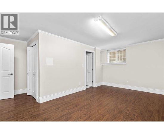 A room with wood flooring and white walls.