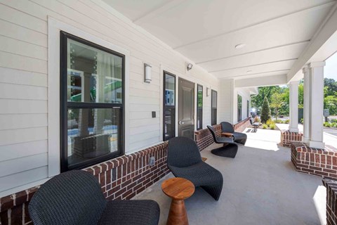 A white building with a balcony has chairs and tables on it.